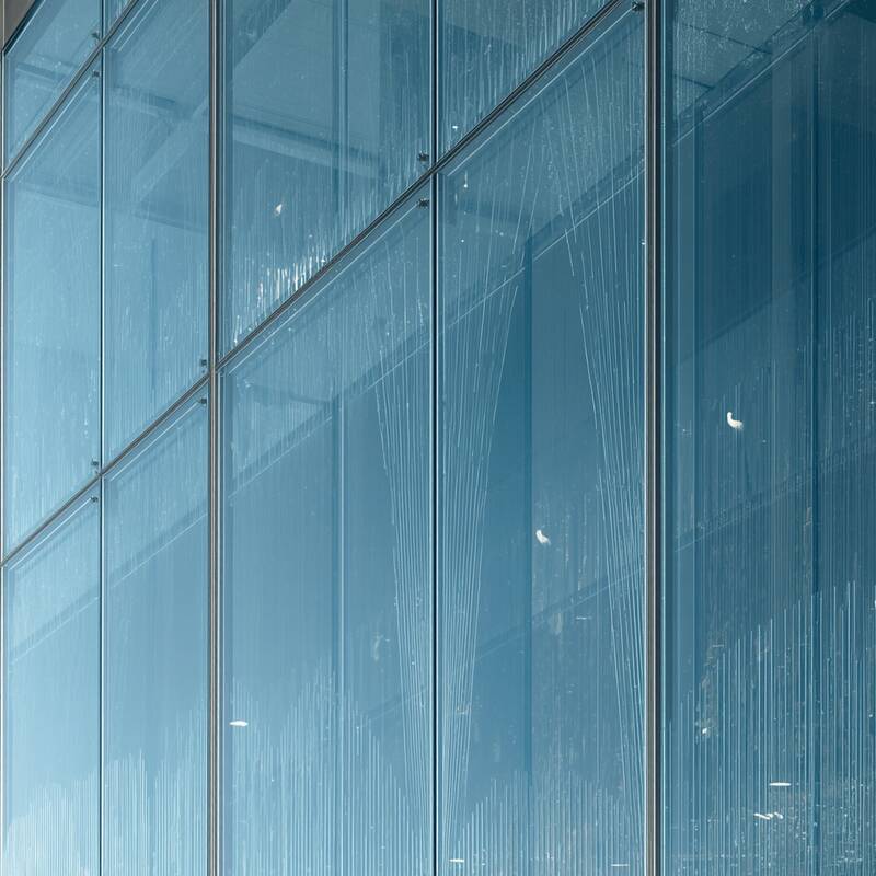 Eine einheitliche, durchgehende Glasfront mit integriertem Vogelschutzglas. Feine, gleichmäßige Linien oder Muster sind über die gesamte Glasfläche verteilt – elegant, dezent und professionell. Moderne Architektur, klare Darstellung